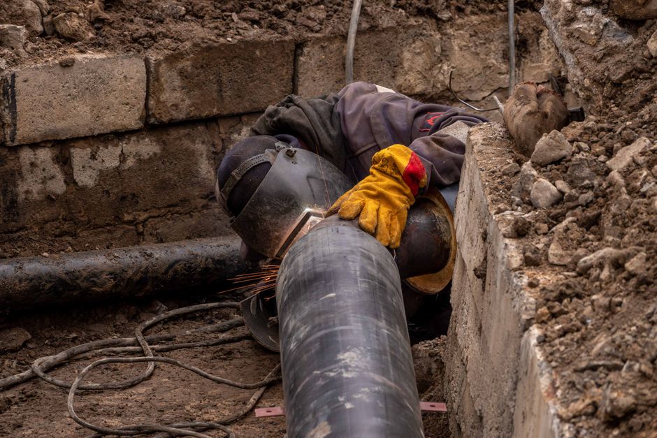 Close-up of a drainage technician inspecting a drain pipe in a Hertfordshire home